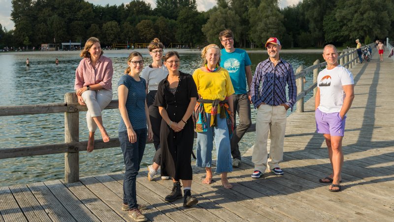 Eine Gruppe steht am Ufer eines Sees