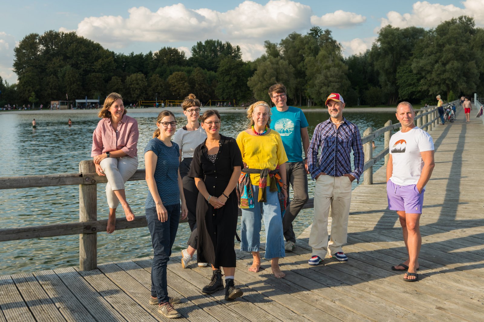 A group is standing on the shore of a lake.