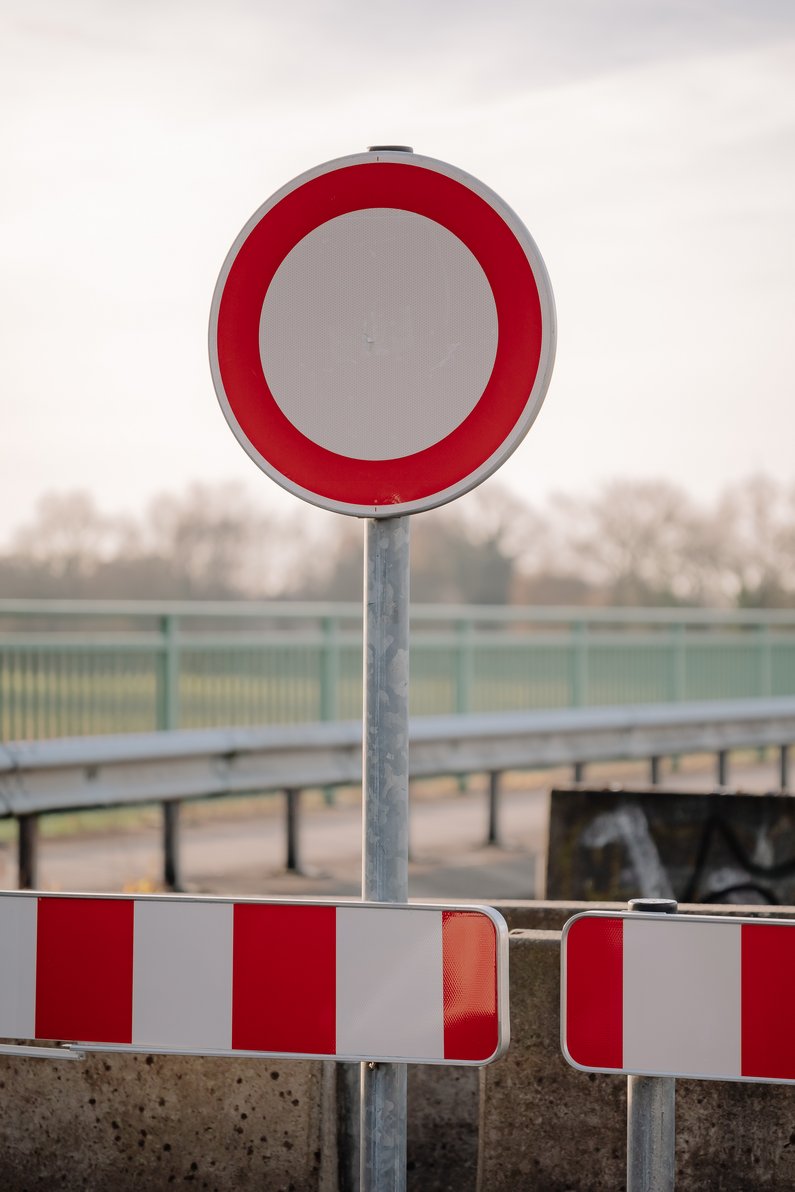 Verkehrschild vor einer abgesperrten Brücke