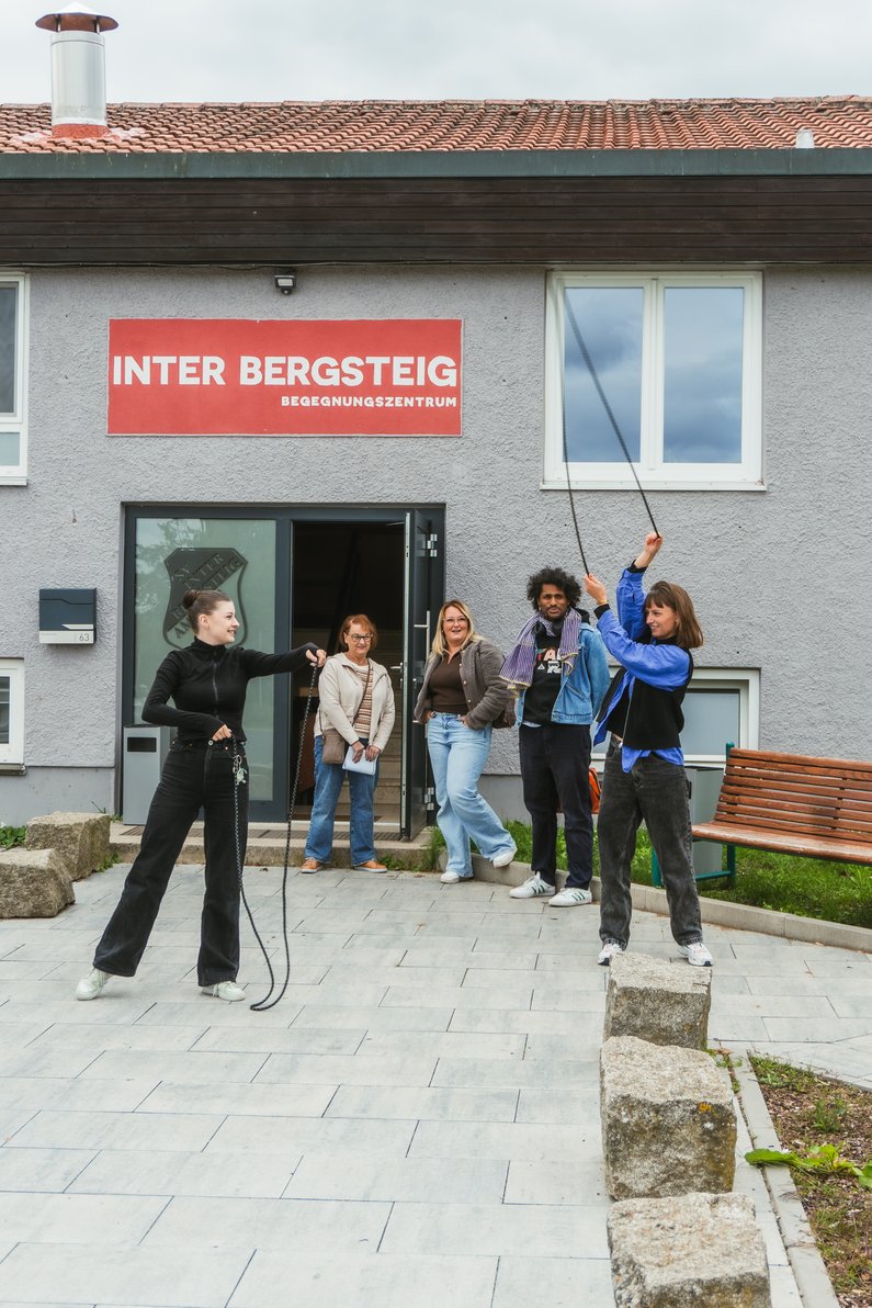 Several people are standing in front of a house entrance holding technical equipment in their hands.
