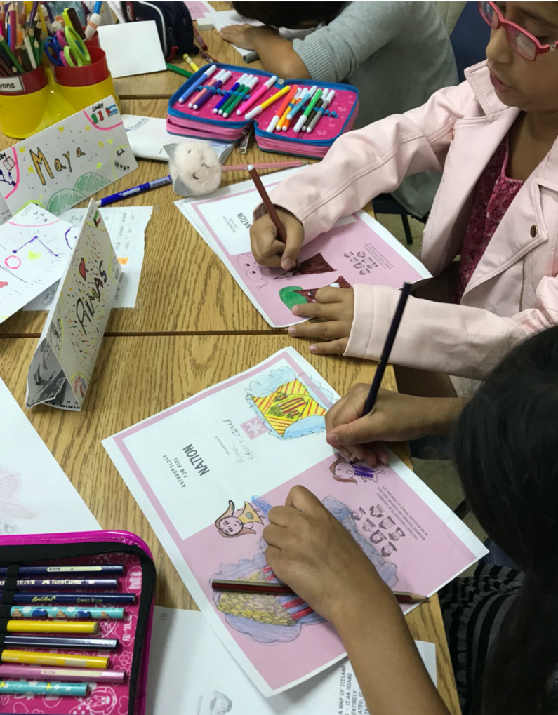 View of children from above working on sketches with many coloured pens