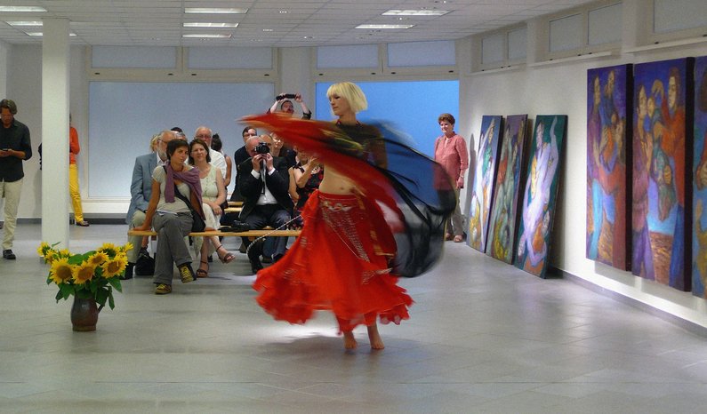 Exhibition space with several art works in Pritzwalk, one person is dancing in the center of the room