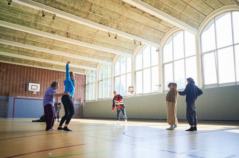 Auftraggeber:innen in der Turnhalle bei Bewegungsworkshop "Passt mein Körper auch rein?"