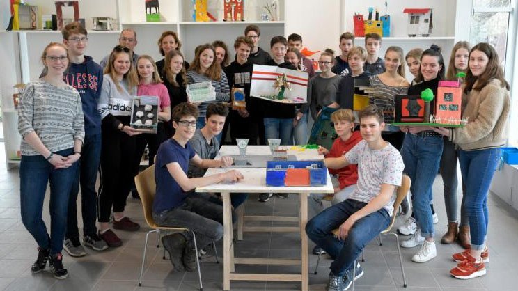 Gruppenbild der Schüler:innen des Hannah-Arendt-Gymnasiums in Potsdam rund um den Tisch mit einigen Modellen des Wünschens
