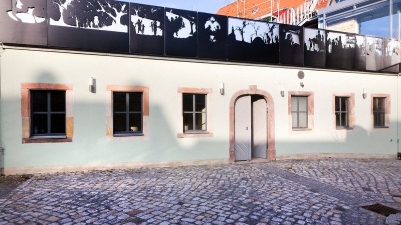 On the roof of the Architektur- und Umwelthaus (AUH) in Naumburg is a frieze made of sheet steel by Henrik Schrat, which shows narrative motifs of the cherry pit legend