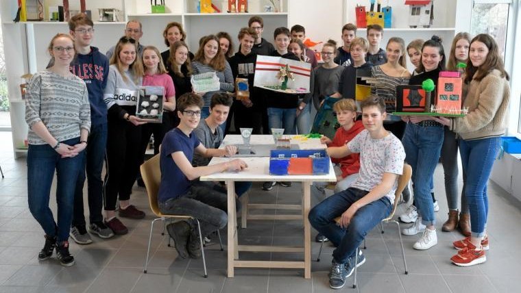 Gruppenbild der Schüler:innen des Hannah-Arendt-Gymnasiums in Potsdam rund um den Tisch mit einigen Modellen des Wünschens