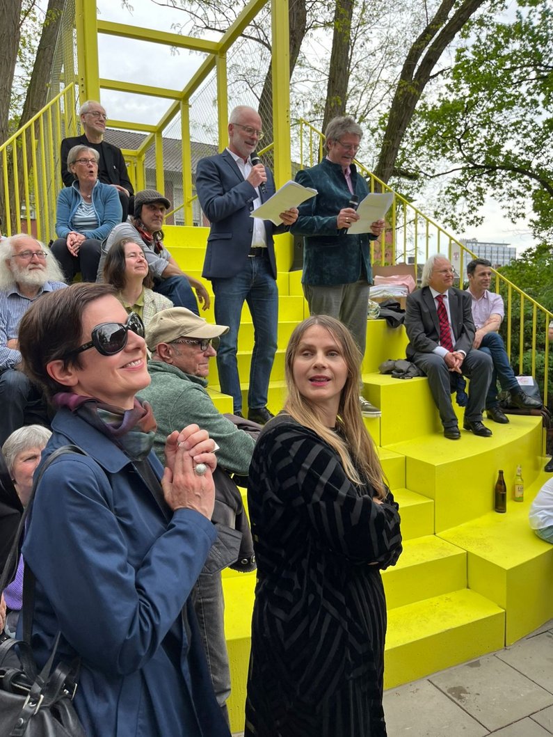 Susanne Titz, Direktorin des Ankerpunktes Museum Abteiberg, mit Künstlerin Ruth Buchanan bei der Rede der Auftraggeber Karl Sasserath und Thomas Hollkott bei der Eröffnung von "Ein Garten mit Brücken" in Mönchengladbach