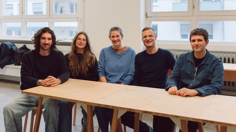 Gruppenfoto von vier Personen an einem Tisch