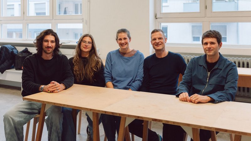 Gruppenfoto von vier Personen an einem Tisch