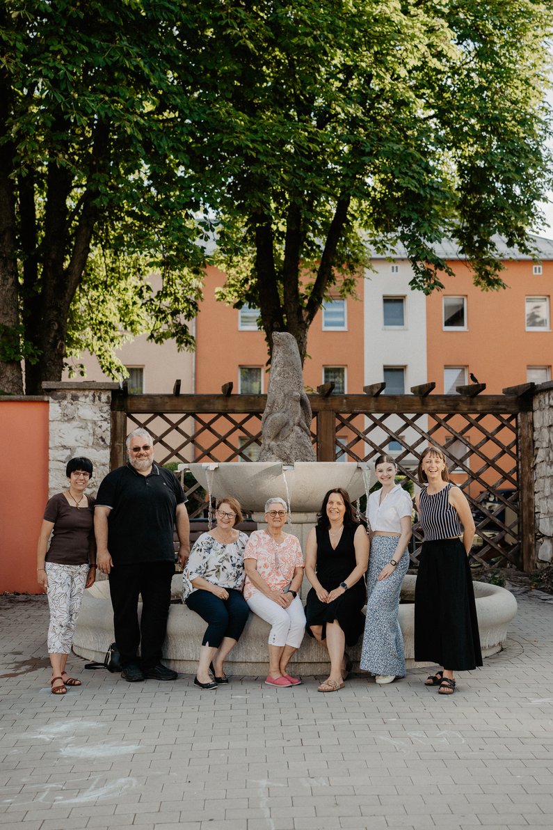 The New Patrons of Amberg – Am Bergsteig Group photo in front of a village well.