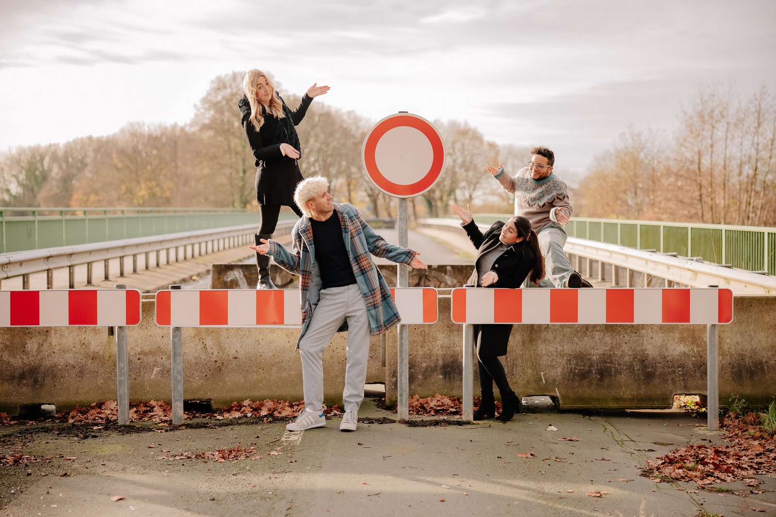 Personen stehen für ein Foto auf und um die Barriere einer abgesperrten Brücke