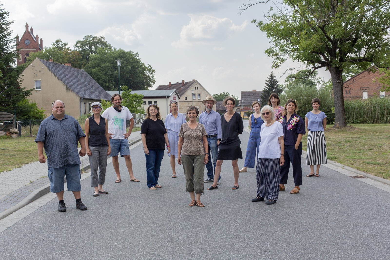 People standing on a street in village facing the observer