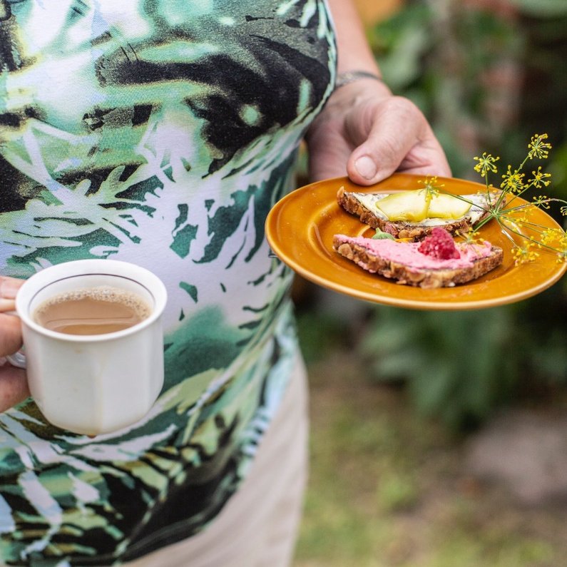 A New Patron of Steinhöfel holding a dish and a tea in her hands