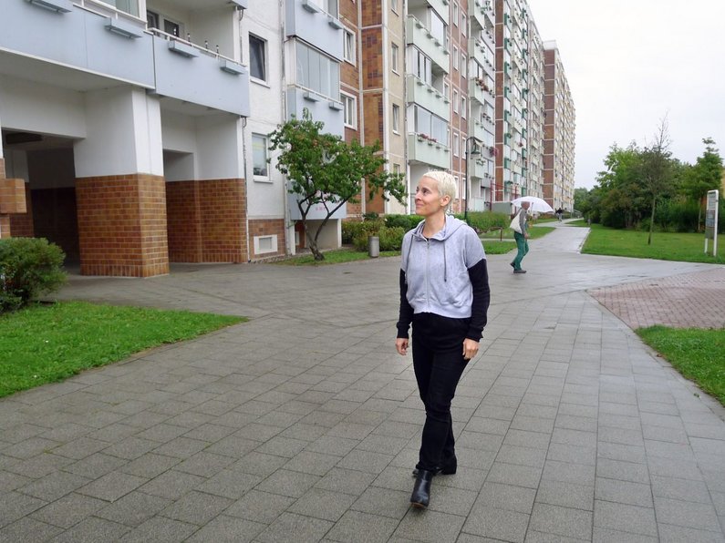 Artist Candice Breitz in front of an apartment block in Rostock 