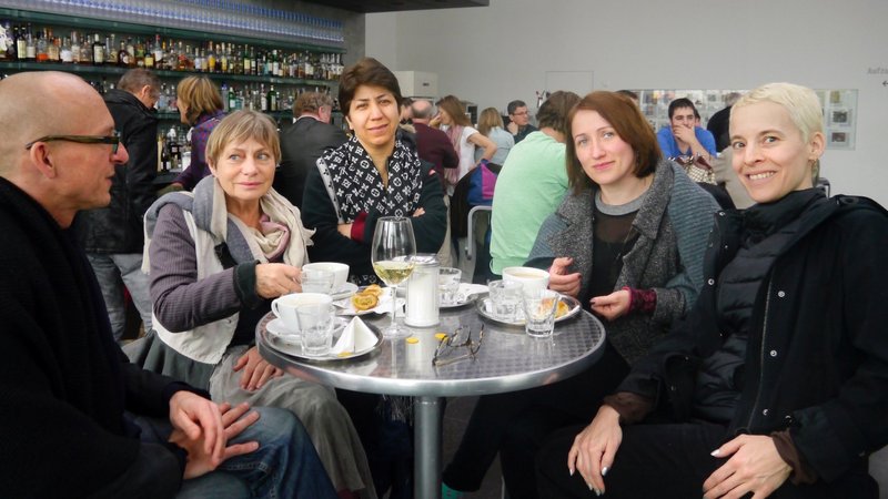 Artist Candice Breitz with Director of New Clients Alexander Koch with New Patrons group sitting in a café in Rostock