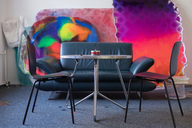 Table, sofa and chairs in front of design element in berlin studio by Daniel Knorr