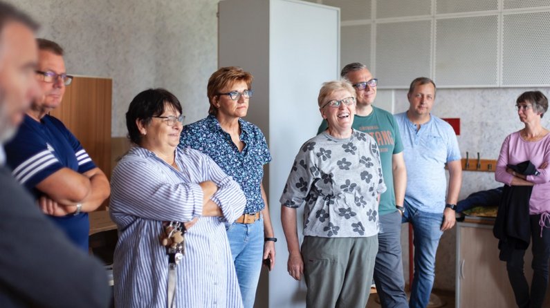 Personen der Neuen Auftraggeber von Züsedom stehen zusammen und diskutieren den Vorschlag von Künstler Jakub Szczesny