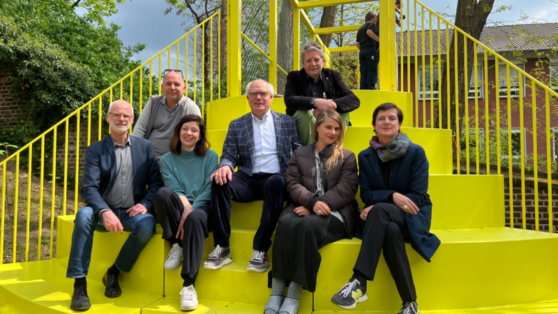 Gruppenfoto auf der gelben Brücke mit Auftraggeber Karl Sasserath, Thomas Hollkott, Uwe Hillekamp (Planung), Ernst Kreuder (Ausführung), Mediatorin Kathrin Jentjens, Künstlerin Ruth Buchanan und Susanne Titz, Direktorin des Ankerpunkts Museum Abteiberg 