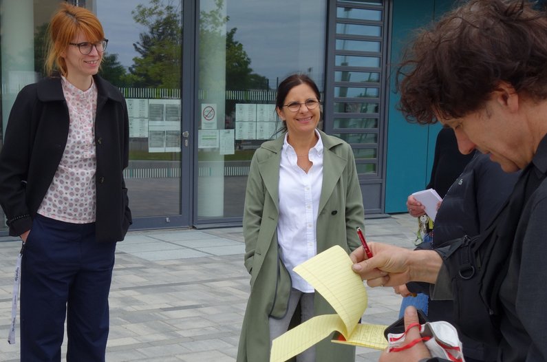 Teachers from Greifswald stand in front of the school with artist Daniel Knorr