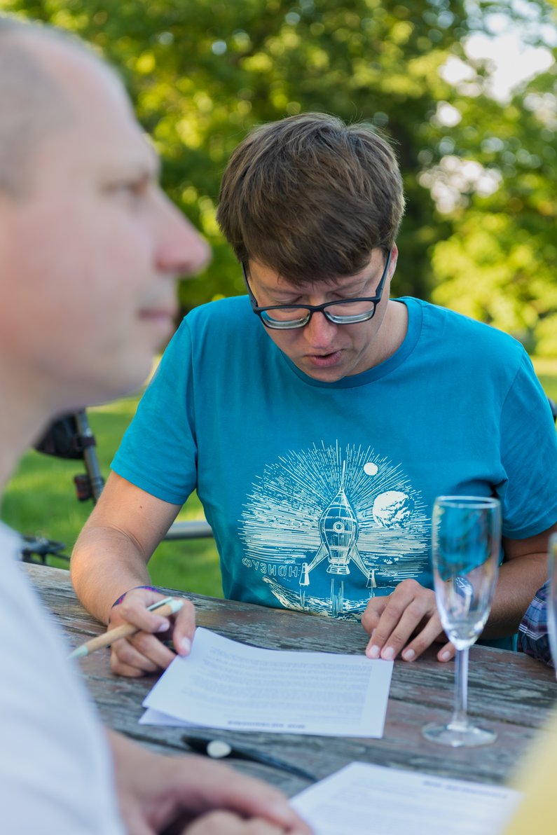 The New Patrons of Neubrandenburg A person reads a document, next to it a filled champagne glass