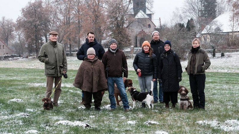 Group photo of The New Patrons' group of Sauen with Ateliers Pompiers, Judith Hopf and Florian Zeyfang and mediator Lea Schleiffenbaum on a field in winter