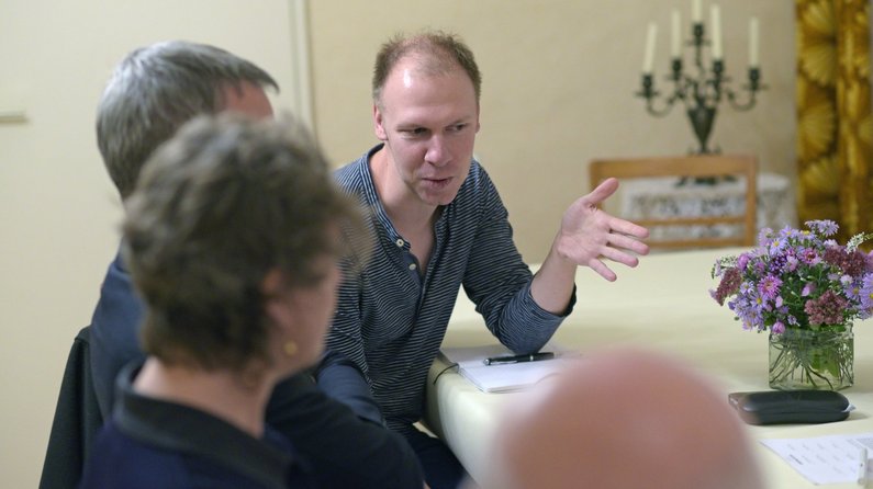 Auftraggeber von Wietstock Martin Müller-Butz sitzt beim Treffen zur Auftragsunterzeichnung mit zwei weiteren Personen am Tisch und spricht