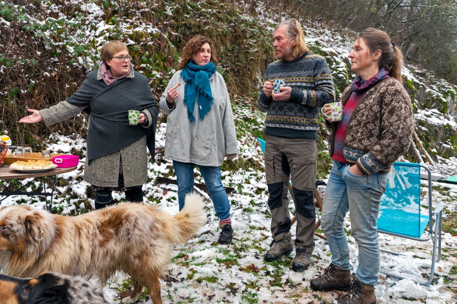 Several persons of The New Patrons of Waldeck-Frankenberg and a dog are standing in the forest discussing